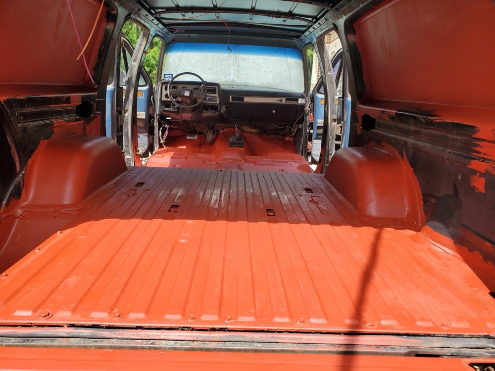 Customer photo of a van cargo floor and wheel wells coated in XionLab red oxide rust converter and primer