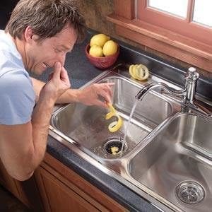 Men pinching his nose above a stinking sink
